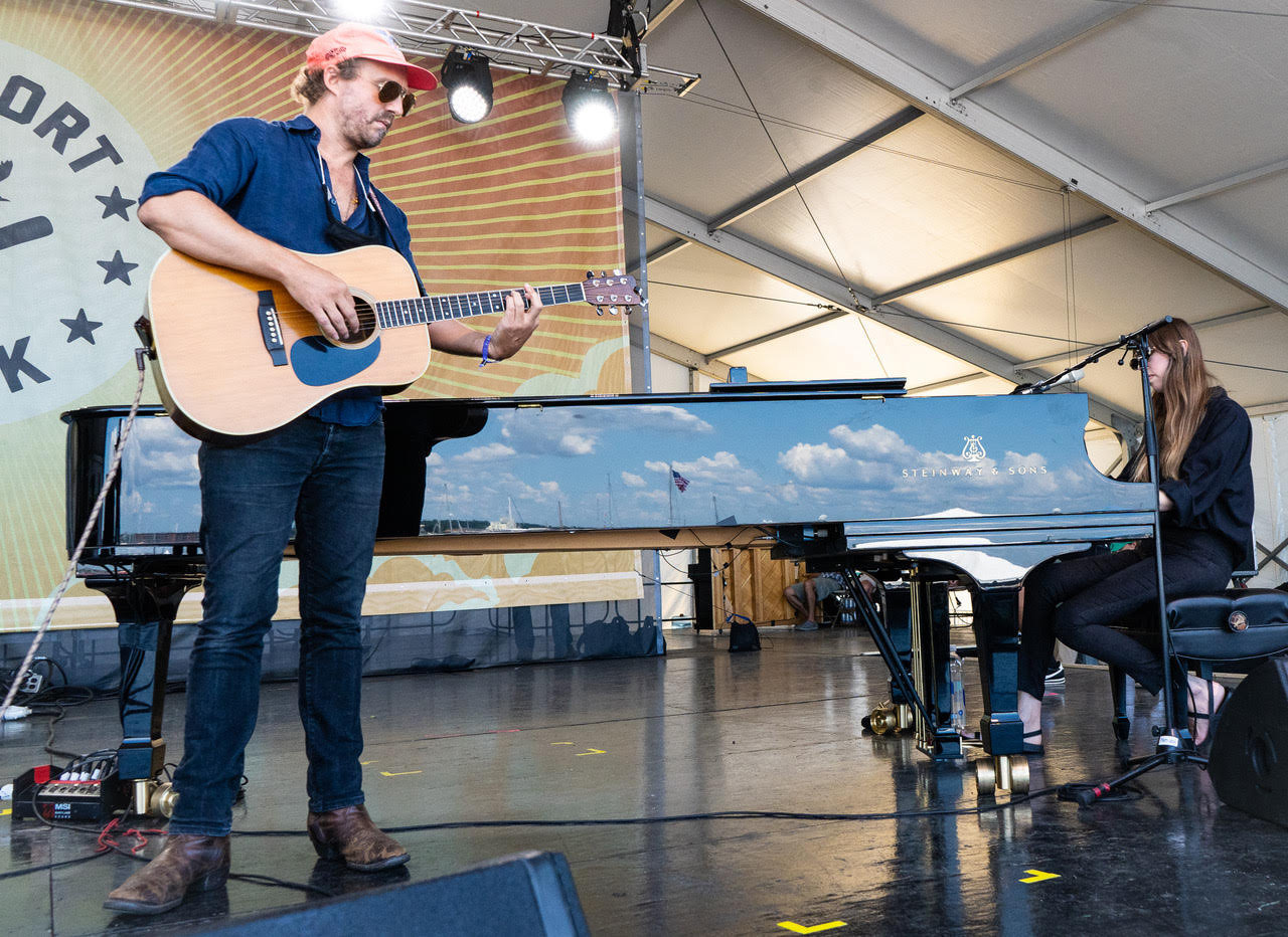 Matthew Houck performs as Phosphorescent at the 2021 Newport Folk Festival, with the sky reflected on the piano.